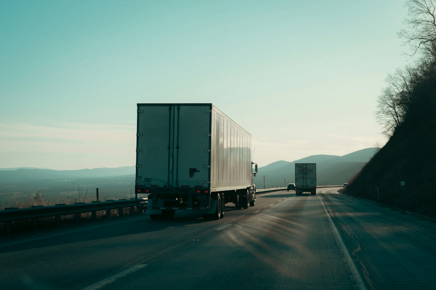 Trucks on a highway with mountains in the background